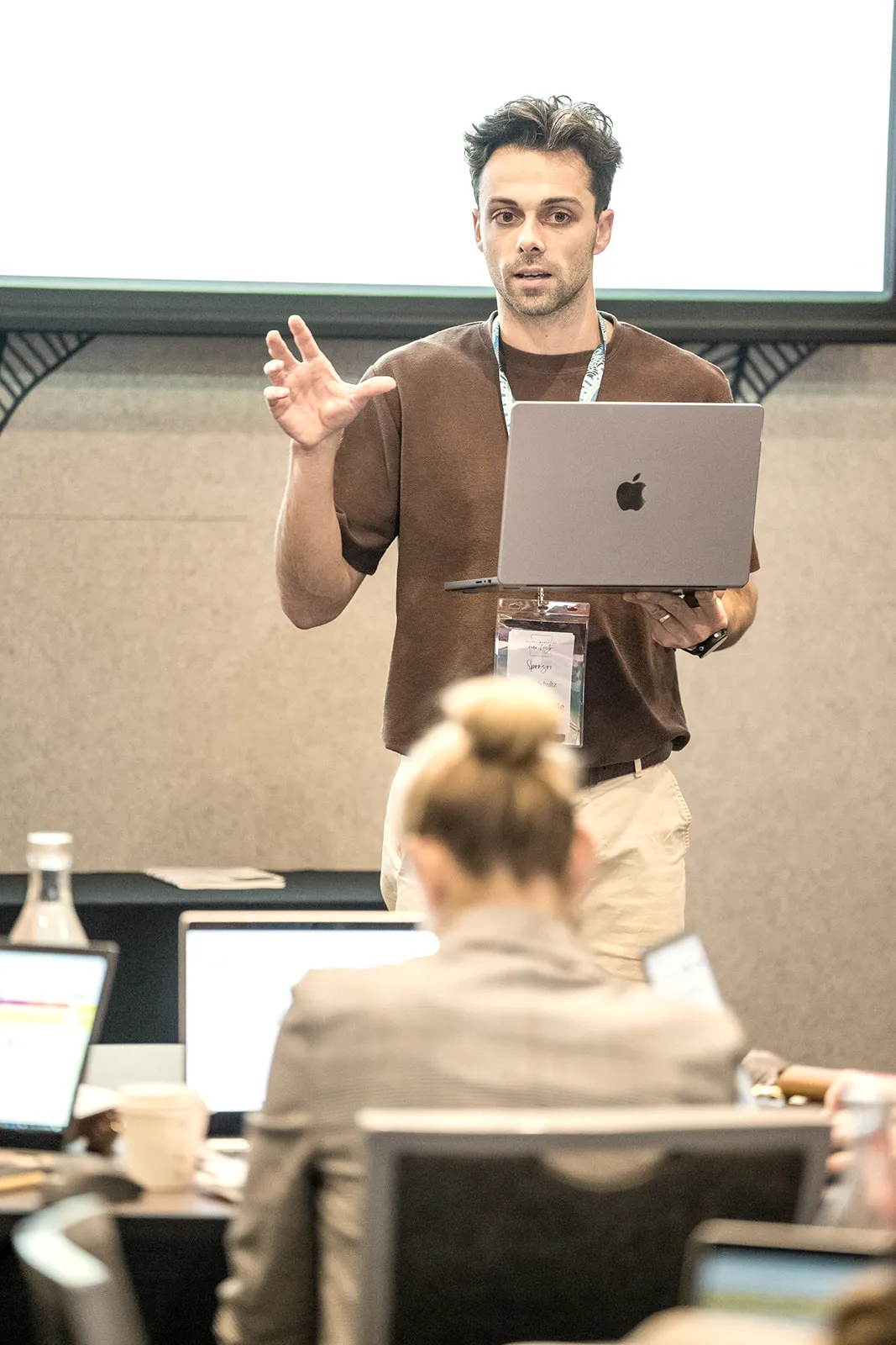 Jacob presenting to a room, laptop in hand