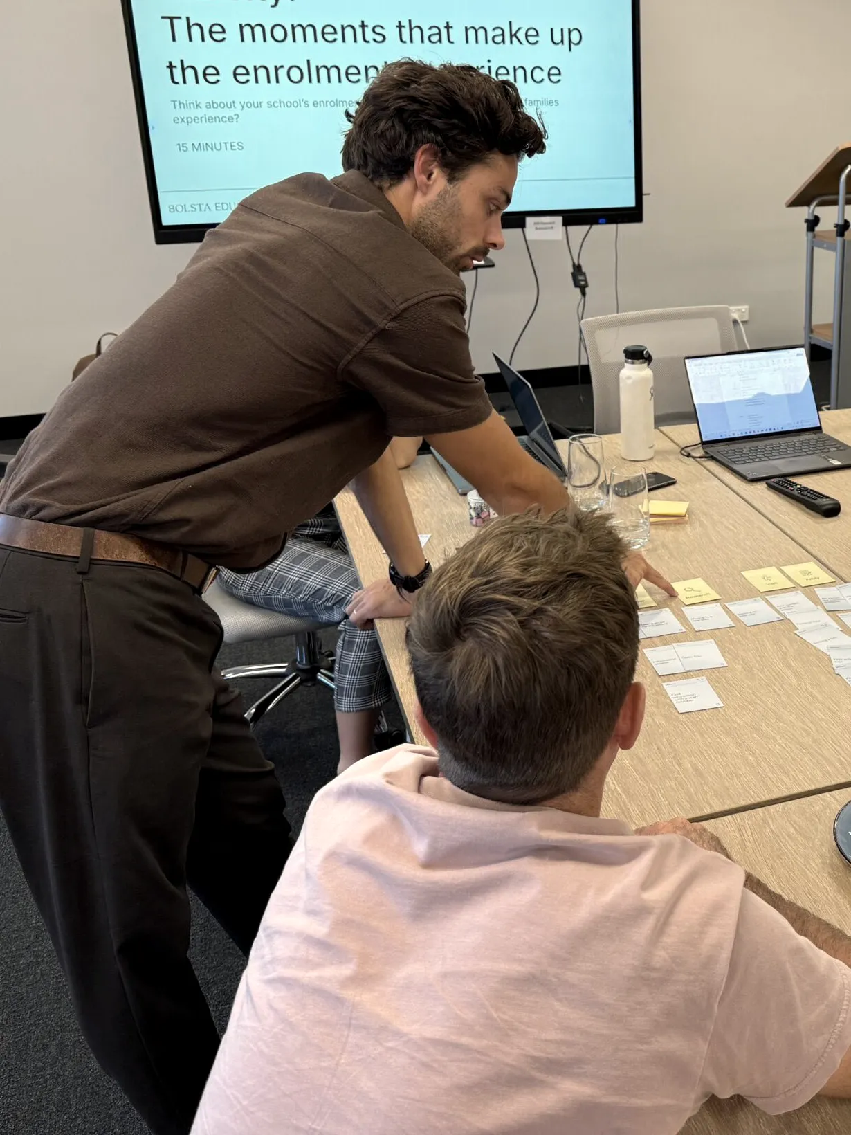 Jacob leaning over a workshop table laid out with cards